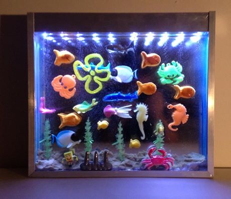 John Bohac. Aquarium. Toys, sand, plastic resin, plexiglas, aluminum, LEDs. 13x15 in. 2014